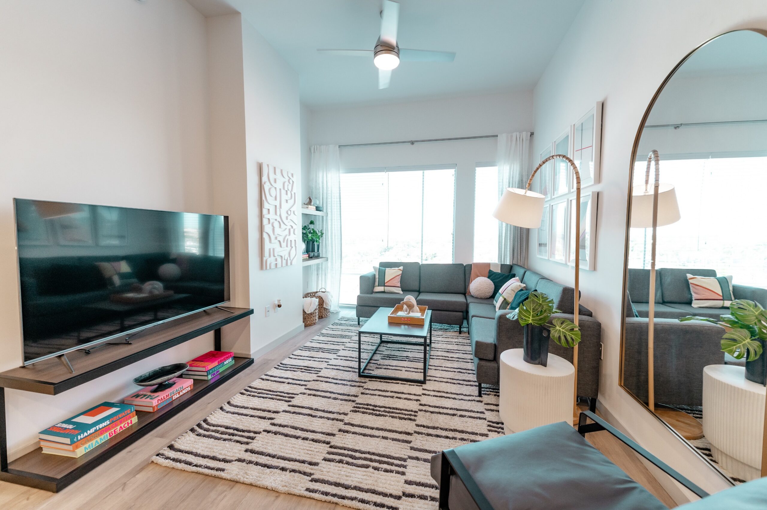 apartment living room grey sectional arch mirror scaled