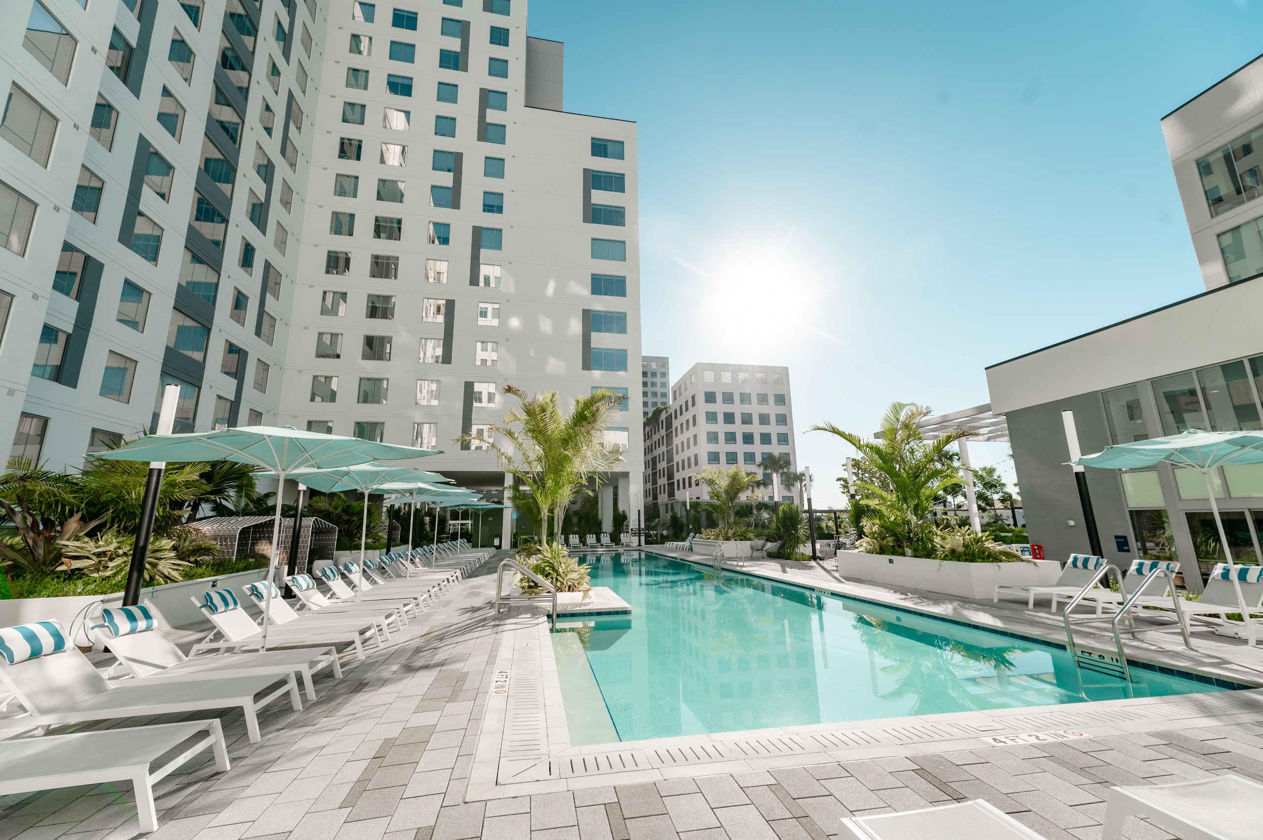 resort style lap pool lounge chairs sun umbrellas